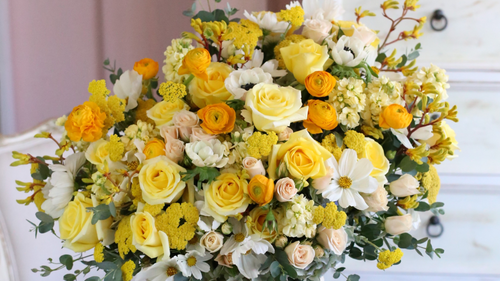 Yellow rose and golden yarrow arrangement with orange ranunculus and cosmos